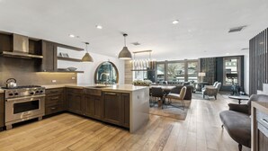 Een moderne keuken met roestvrijstalen apparatuur, houten kastjes en een groot eiland.