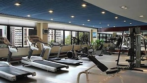 Ein Fitnessstudio mit Laufbändern, Ergometer und Krafttrainingsgeräten.