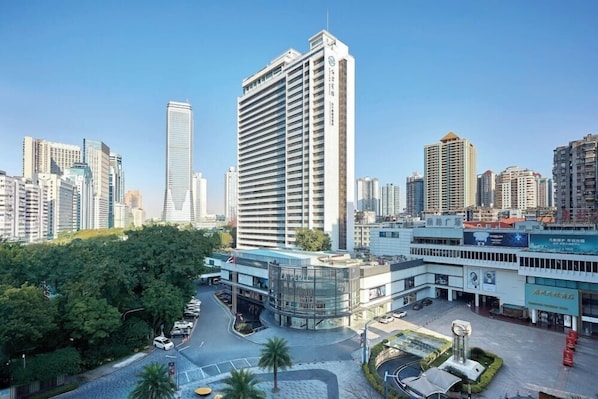 Un hôtel de grande hauteur au design moderne, doté d  ’une cour intérieure et offrant une vue sur le paysage urbain environnant.