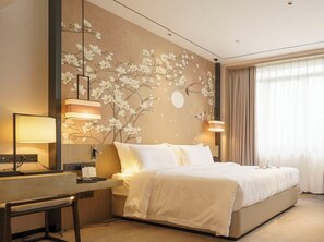 Une chambre d’hôtel avec un lit, une table de chevet, une lampe et une fresque murale.