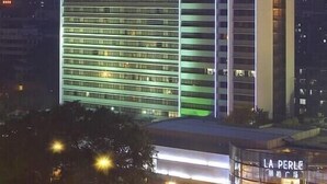 Ein Hochhaus-Hotel mit mehreren Etagen, einer markanten Dachkonstruktion und beleuchteter Beschilderung.