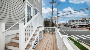 Un immeuble résidentiel doté d’une terrasse en bois et de balustrades blanches.