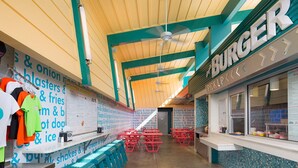 L’intérieur d’un restaurant de restauration rapide, avec un comptoir, un espace pour les clients et des panneaux affichant le menu.