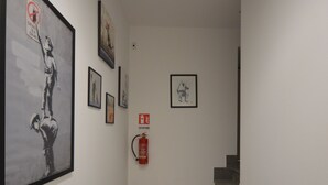 A staircase with a fire extinguisher mounted on the wall and framed artwork on the walls. - SanRemo Apartment (Roma)