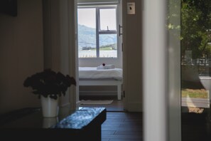 Un dormitorio con cama, ventana y planta.