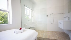 Een moderne badkamer met douche, toilet en wastafel.