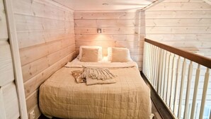 A cozy room with a bed, a small table, and a window. - Villa Tähkä, HimosYkkösen alue (Keski-Suomi)