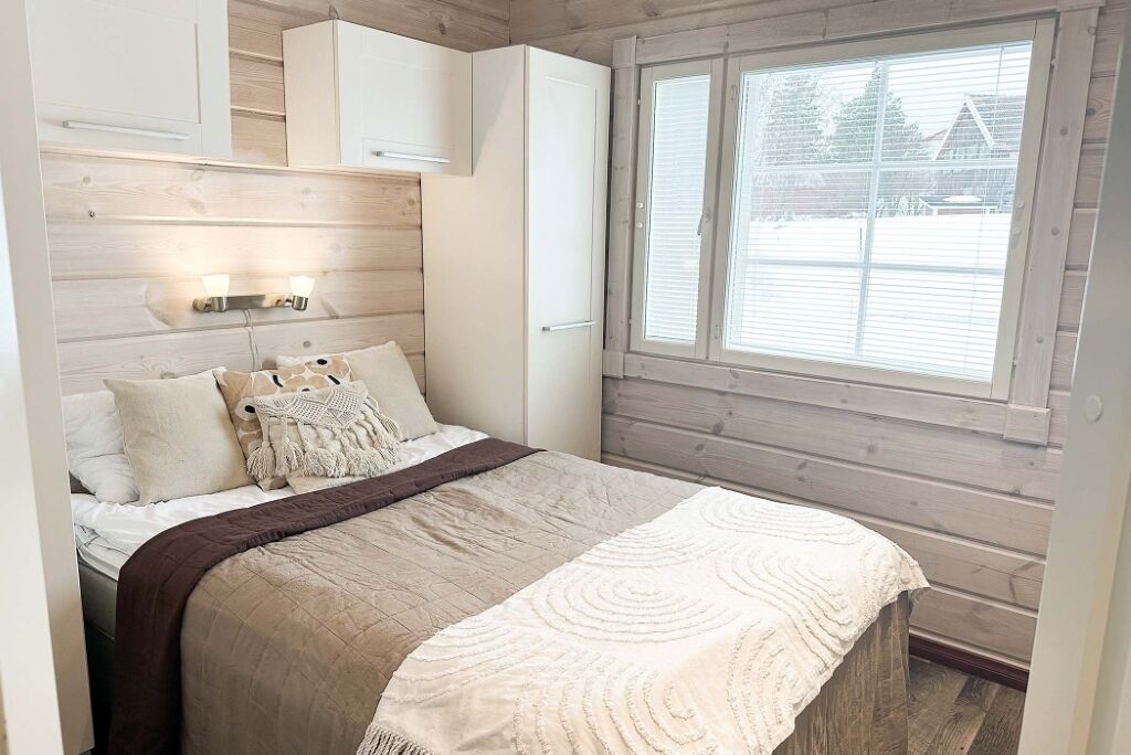 Une chambre à coucher avec un lit, une fenêtre et une tête de lit en bois.