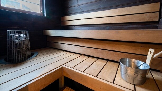 A wooden bench with a metal bucket and a cage with a bird. - Villa Tähkä, HimosYkkösen alue (Keski-Suomi)