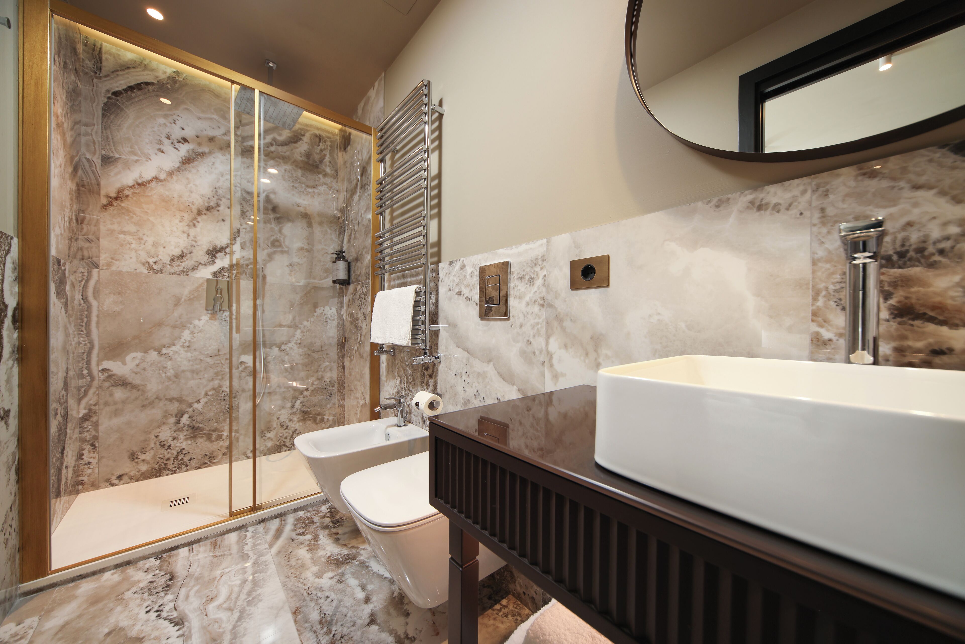 A modern bathroom with a large bathtub, a separate sink, and a glass-enclosed shower area.