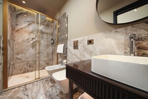 A modern bathroom with a large bathtub, a separate sink, and a glass-enclosed shower area.