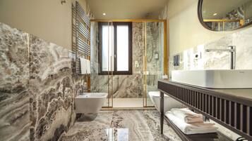 A modern bathroom with a marble floor, a freestanding bathtub, a sink, and a mirror.
