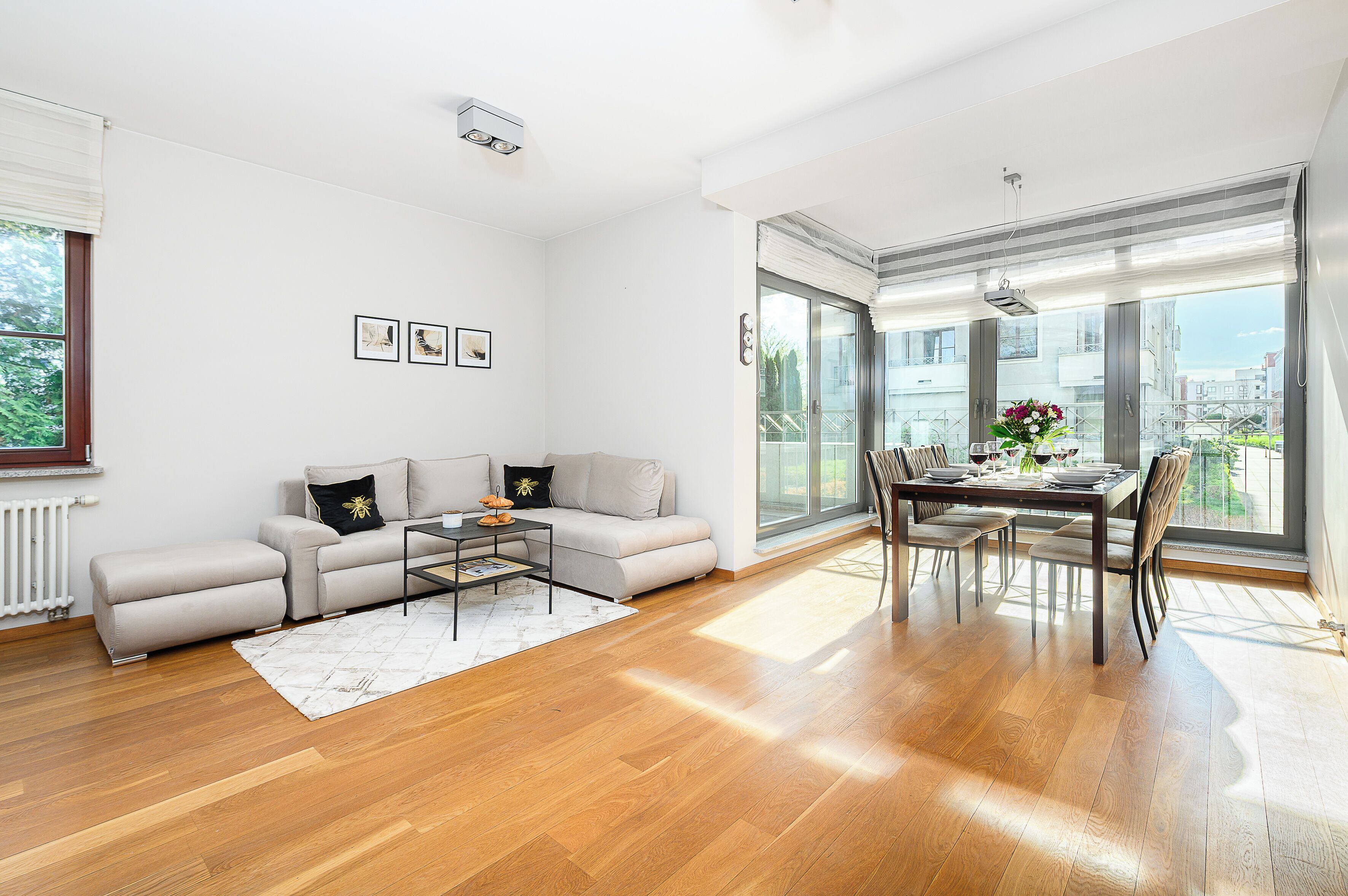 Uma sala de estar moderna com sofá, mesa de centro e área de jantar.