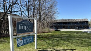 A motel sign with a boathouse rental sign below it.