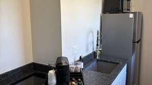A compact kitchen with a built-in stovetop, a microwave, and a refrigerator. - Juniper Motel-King Suite-Room 22*Cook Top*Waterfront*Lake Access*Dock (Greenville)