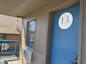 A blue door with the number 13, a window, and a porch with a railing. - Juniper Motel *Double Queen*RM13*ATV Access*Dock*Waterfront (Greenville)