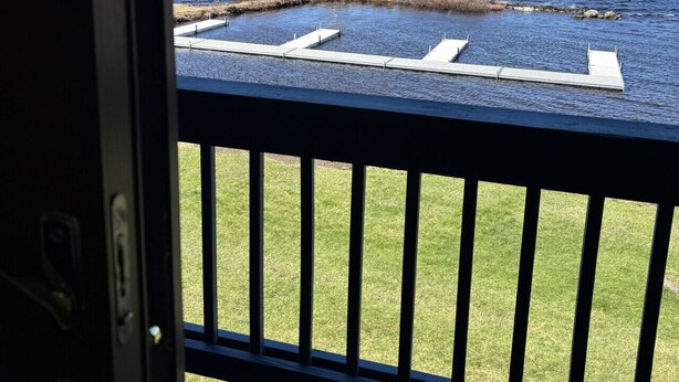 A view from a window overlooking a lake with a dock and grassy area. - Juniper Motel*Double Queen*RM 14*Waterfront*Pet Friendly*Dock (Greenville)
