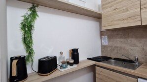 Una cucina compatta con mobili in legno, lavello incassato e un piccolo piano di lavoro.