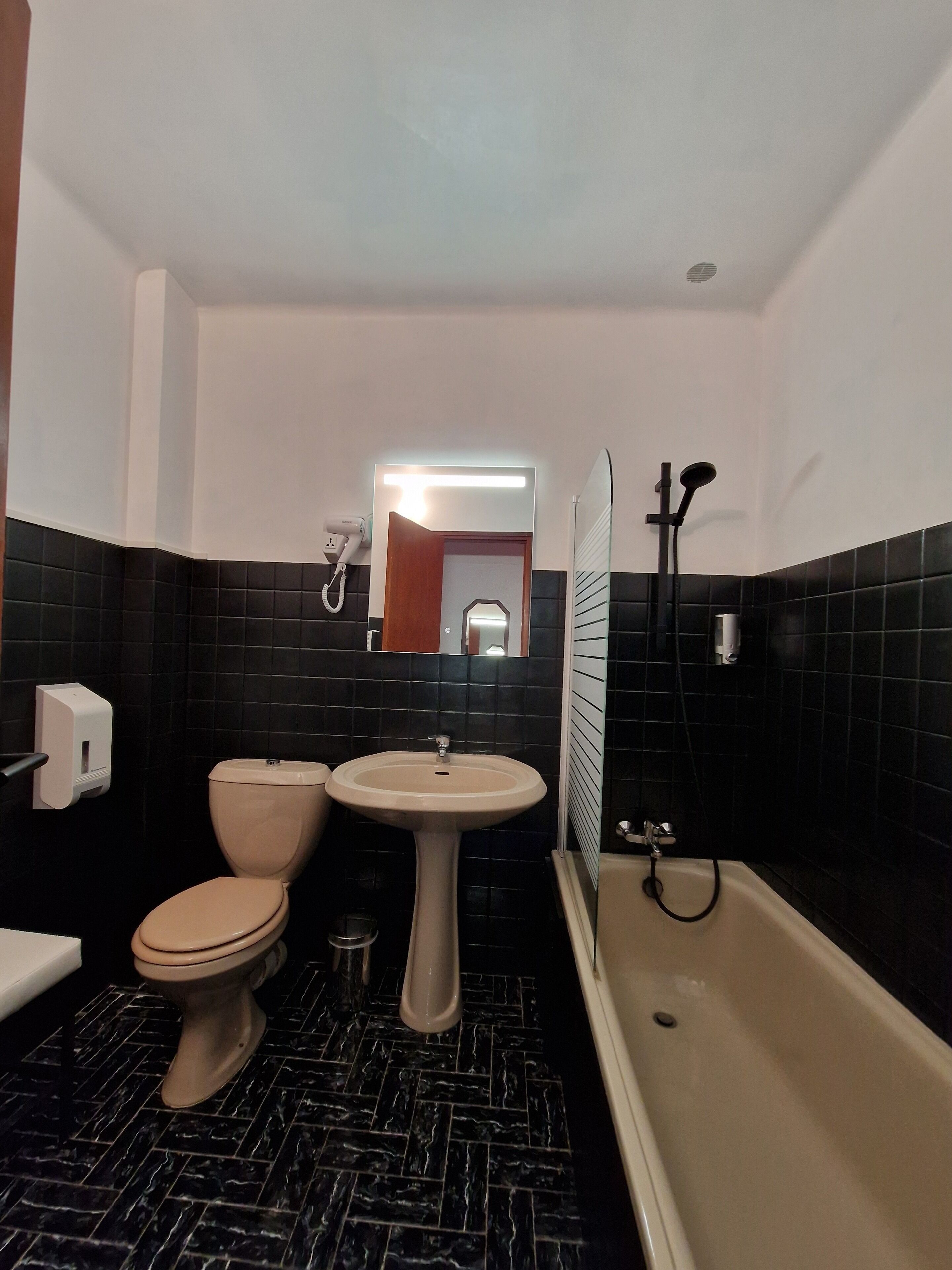 A bathroom with a toilet, sink, and bathtub.