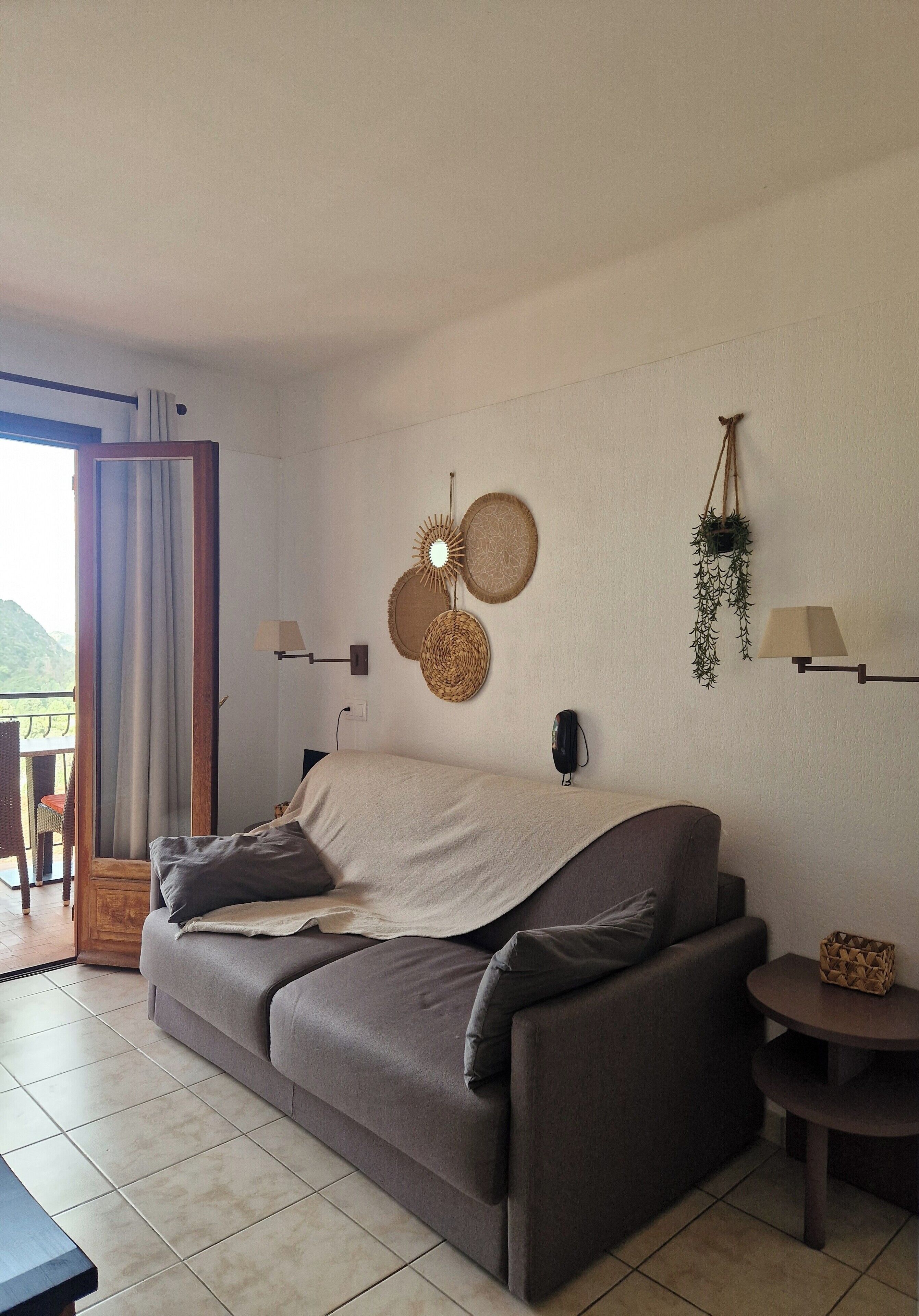 Un salon moderne avec un canapé, une petite table et un balcon offrant une vue agréable.