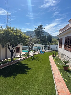 Enjoy a serene escape amidst lush greenery and a majestic mountain backdrop.