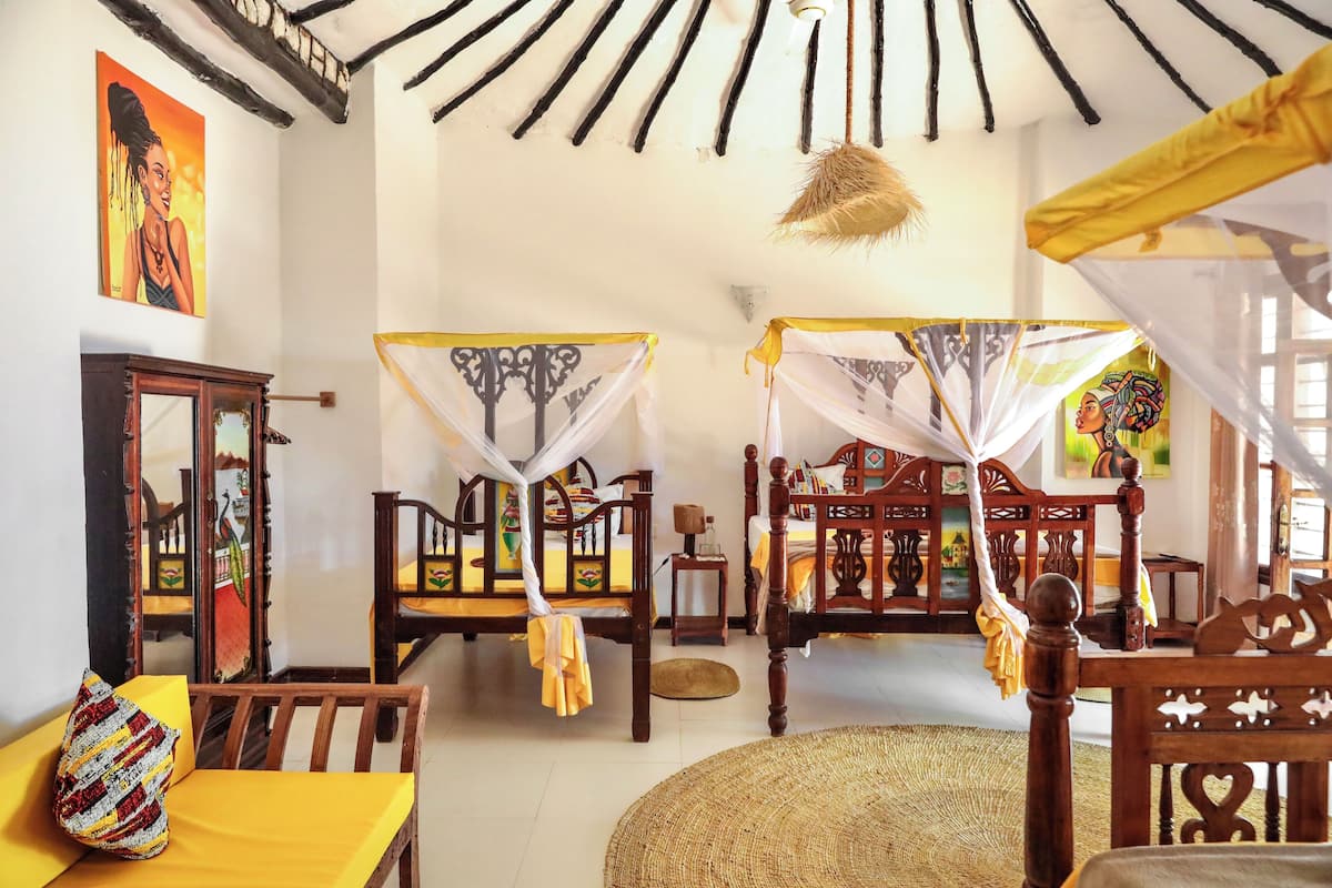 A traditional room with wooden furniture, a woven mat on the floor, and a bed with a canopy.