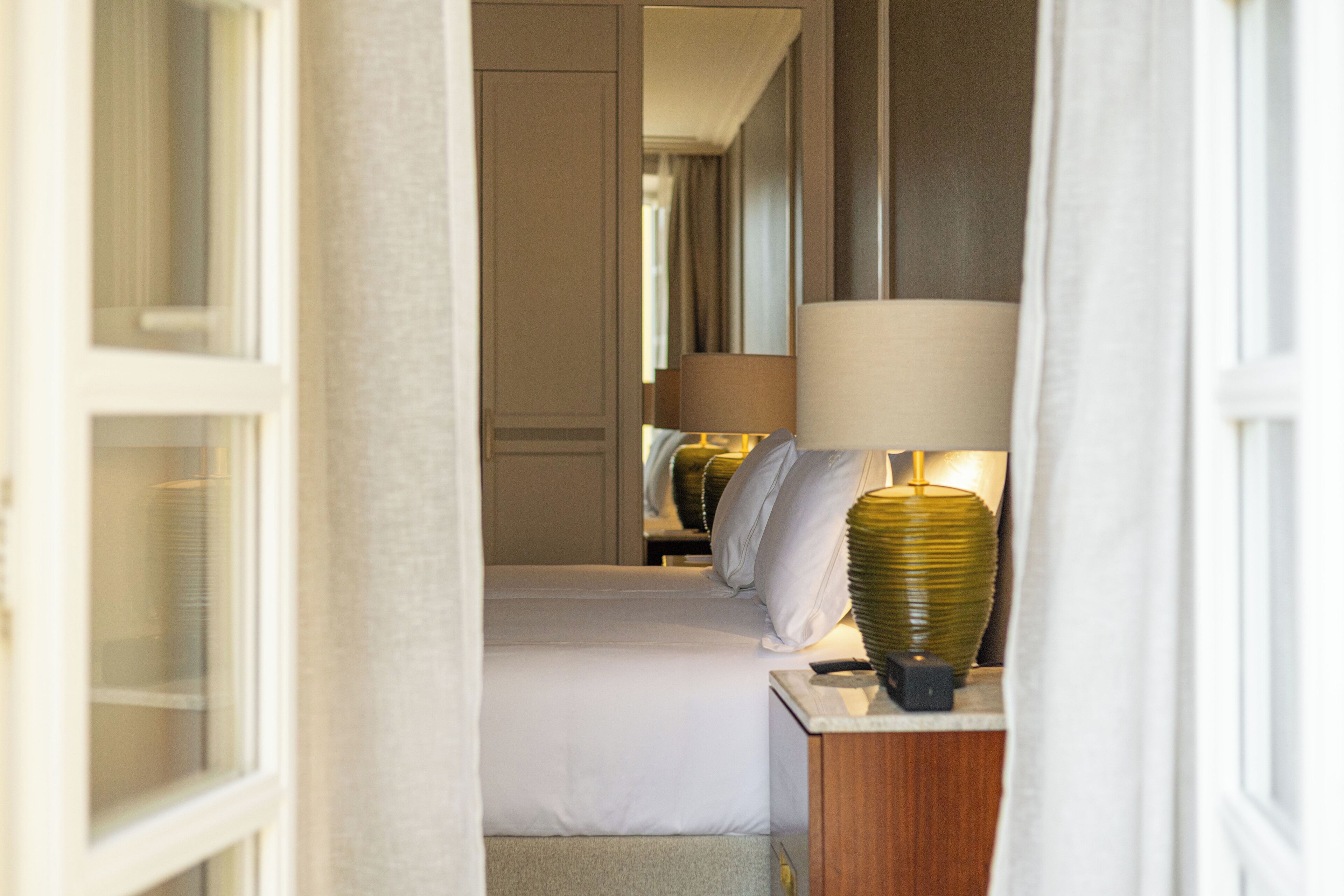 Une chambre d’hôtel avec un lit, une table de chevet et une lampe.