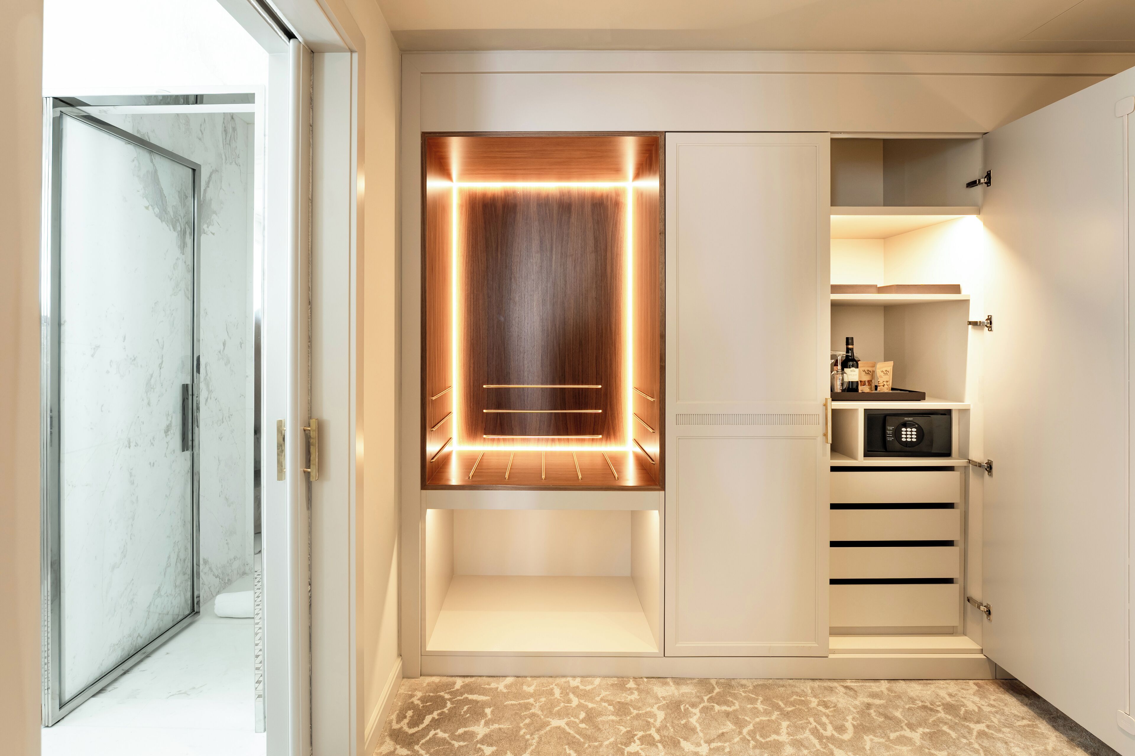 A modern closet with built-in lighting, a microwave, and a wine cooler.
