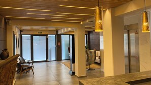 Un lobby moderno con techo de madera, una recepción y un área de descanso.