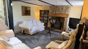 Un salon chaleureux avec une cheminée, un canapé et deux fauteuils.