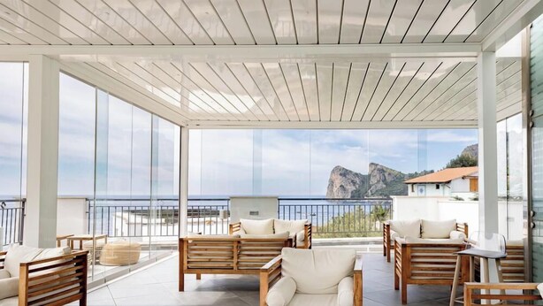 A spacious outdoor seating area with wooden furniture and a view of the sea. - Hotiday Room Collection - Nerano (Marina del Cantone)