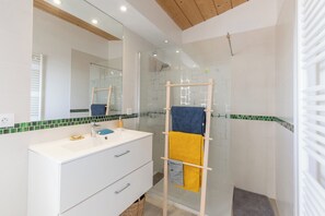 Een douche, handdoeken, zeep, toiletpapier