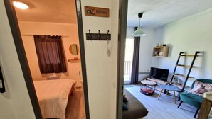 A cozy room with a bed, a small desk, a TV, and a sofa. - Ski-in/ski-out & foot of the slopes, 3rd floor, view ski slopes, balcony, tv, ski locker, 28m² (Valfréjus)