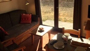 Uma sala de estar acolhedora com um sofá, uma mesa de centro e um espaço de jantar com uma mesa posta para refeição.