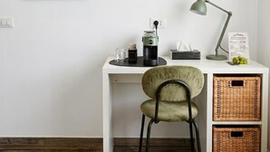 A white desk with a chair, a framed picture, a lamp, and wicker baskets. - WelcHome Vitorchiano double room with balcony  (Vitorchiano)