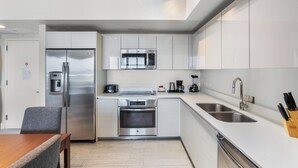 Una cocina moderna con electrodomésticos de acero inoxidable, microondas integrado y cafetera.