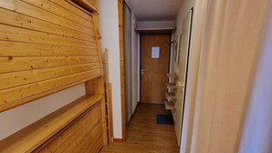 Un estrecho pasillo con paneles de madera en un lado y una cortina color beige en el otro.