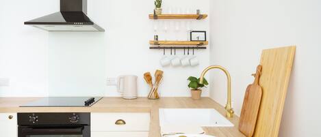 A modern kitchen with a built-in oven, a sink, and a wooden countertop.