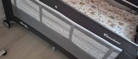 A convertible sofa bed with a mesh side panel and a patterned fabric cover.