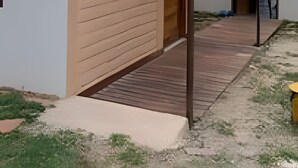 A modern building with a covered patio area, a wooden deck, and a clear sky. - Chalet 800 meters from Chapada dos Veadeiros Park, Wi-Fi (Alto Paraíso de Goiás)