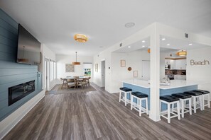Une cuisine moderne dotée d’un îlot central intégré, d’un coin repas avec une table et des chaises en bois, et d’un îlot de cuisine avec des tabourets de bar.
