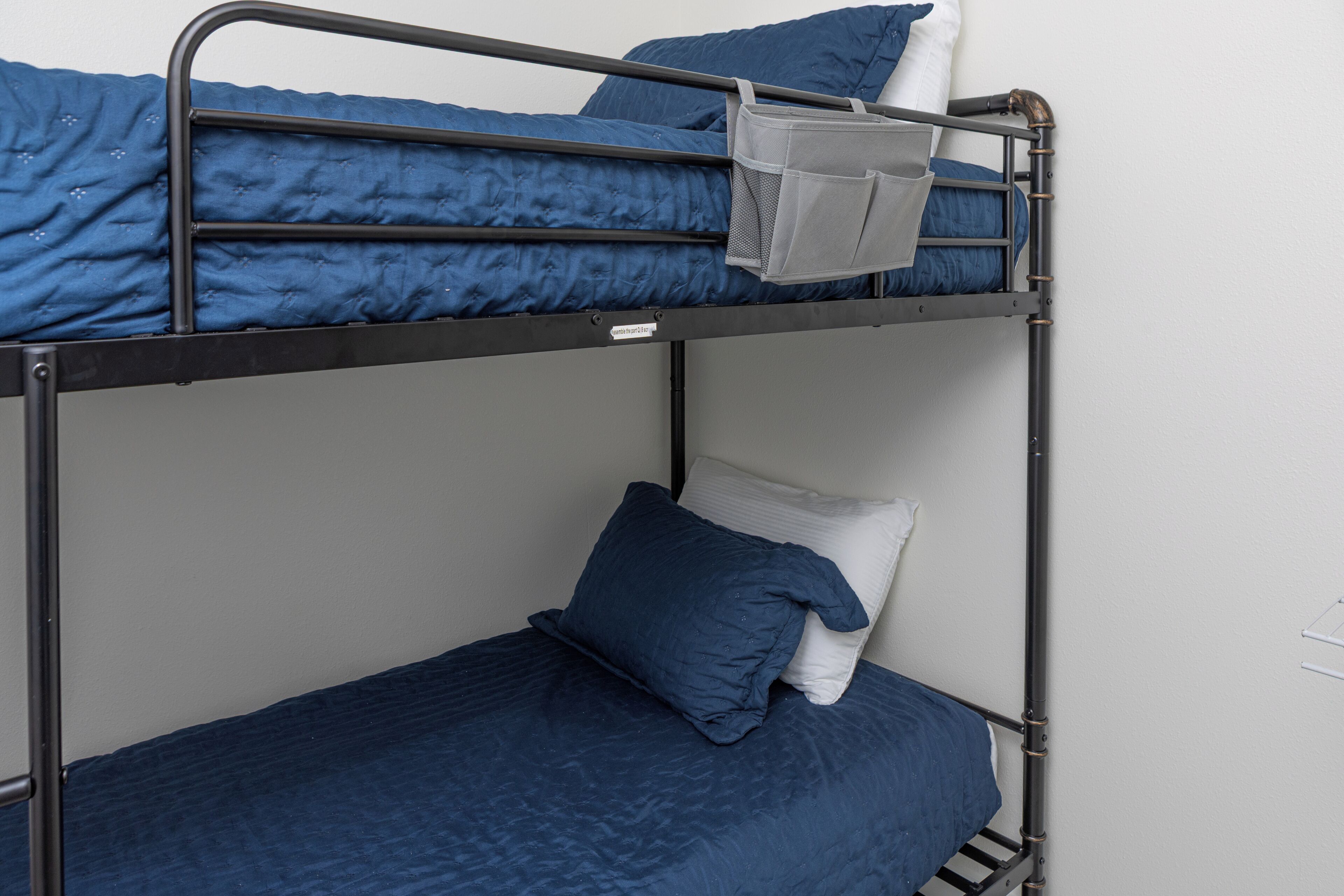 A bunk bed with blue bedding and a white pillow.