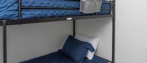 A bunk bed with blue bedding and a white pillow.