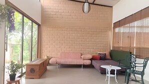 Una sala de estar acogedora con pared de ladrillo, un sofá, un sillón, una mesita y una silla.