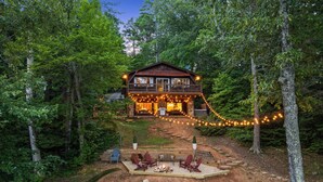 Un chalet rustique doté d’une terrasse, d’un espace salon extérieur et d’un foyer.