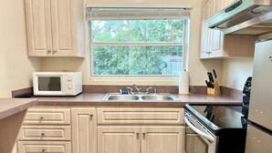 A compact kitchen with a microwave, sink, and stove.