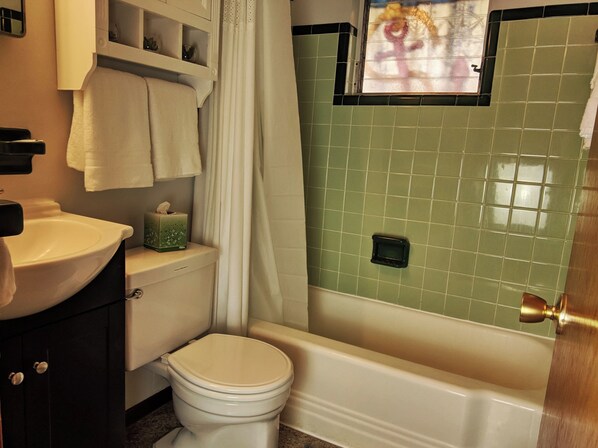 A bathroom with a toilet, sink, and bathtub.
