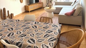 Una sala de estar con sofá, televisión y detalles decorativos en la pared.