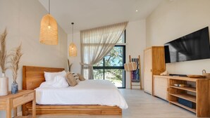 A modern bedroom with a wooden bed, a TV, and a large window.