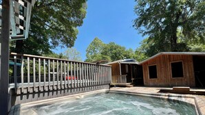 Un espace avec un jacuzzi, une terrasse en bois et une clôture.